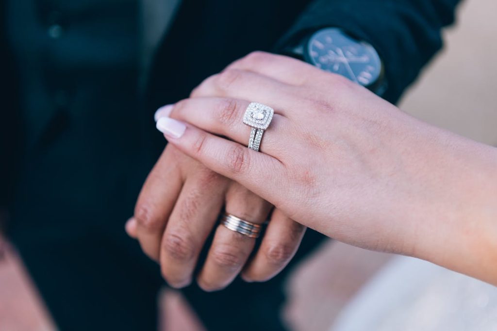 a picture of a bride's hand wearing a diamond-studded ring